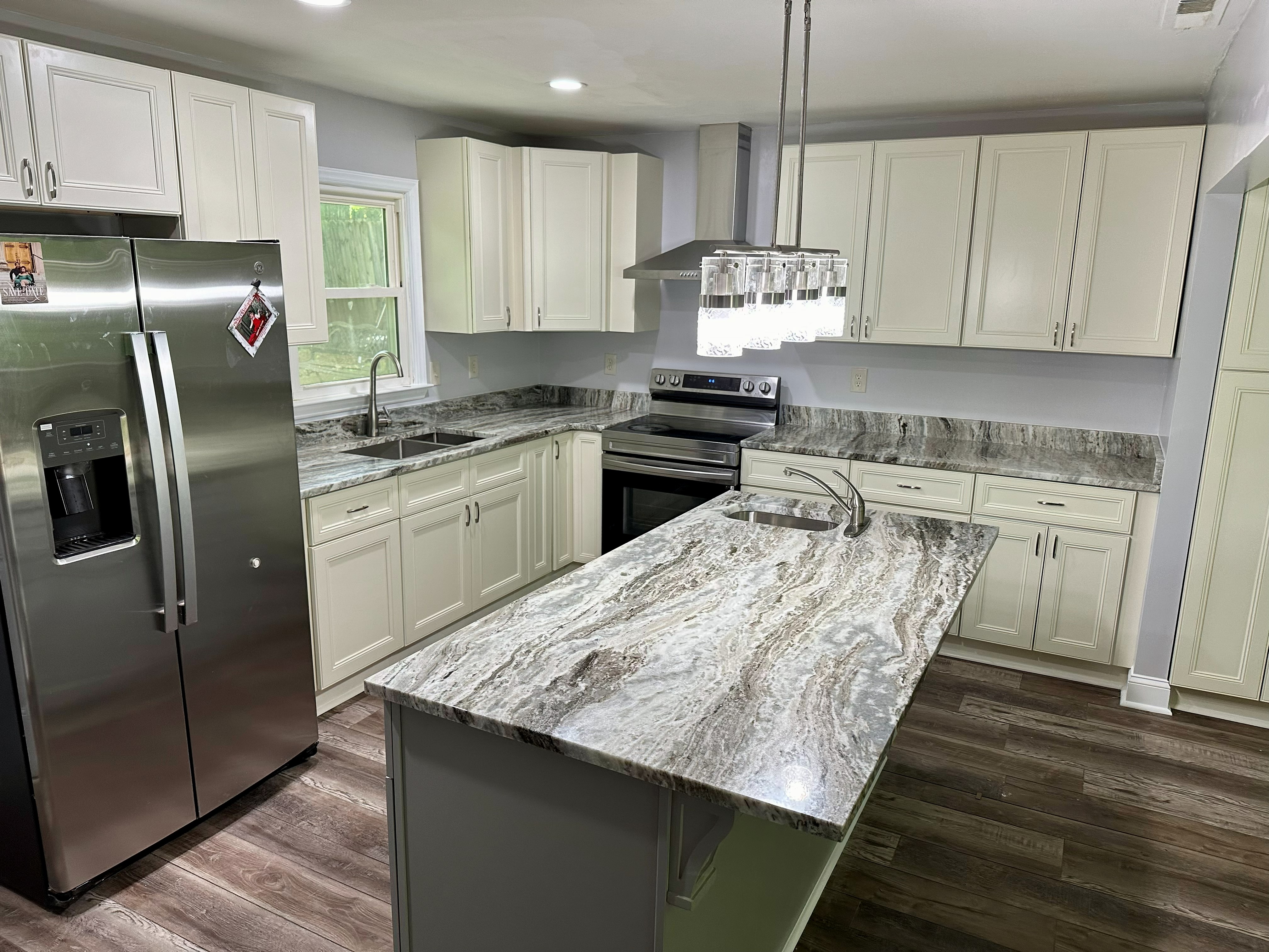 Finished kitchen with island and white cabinetry
