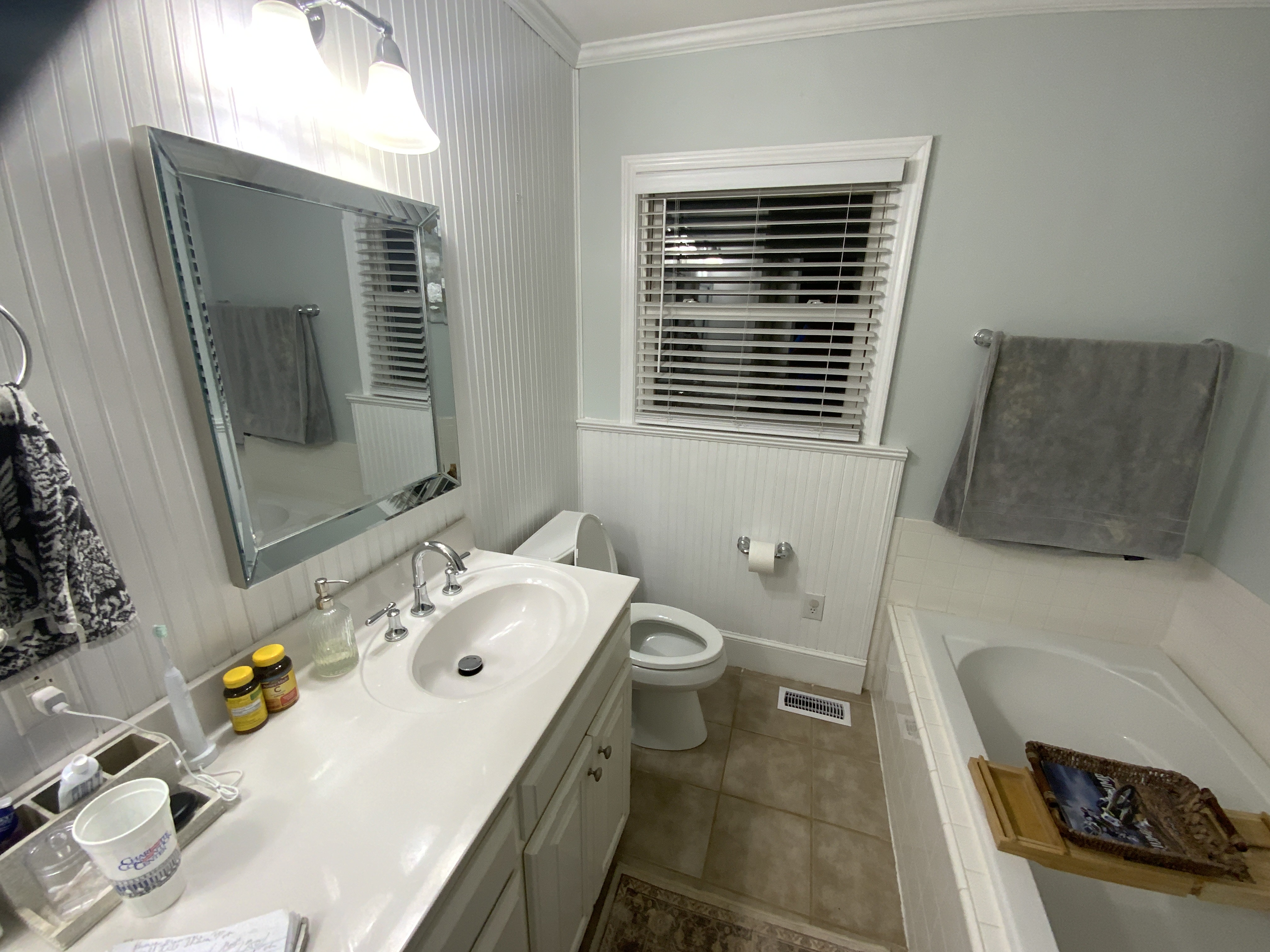 Finished bathroom with a long double vanity and polished fixtures